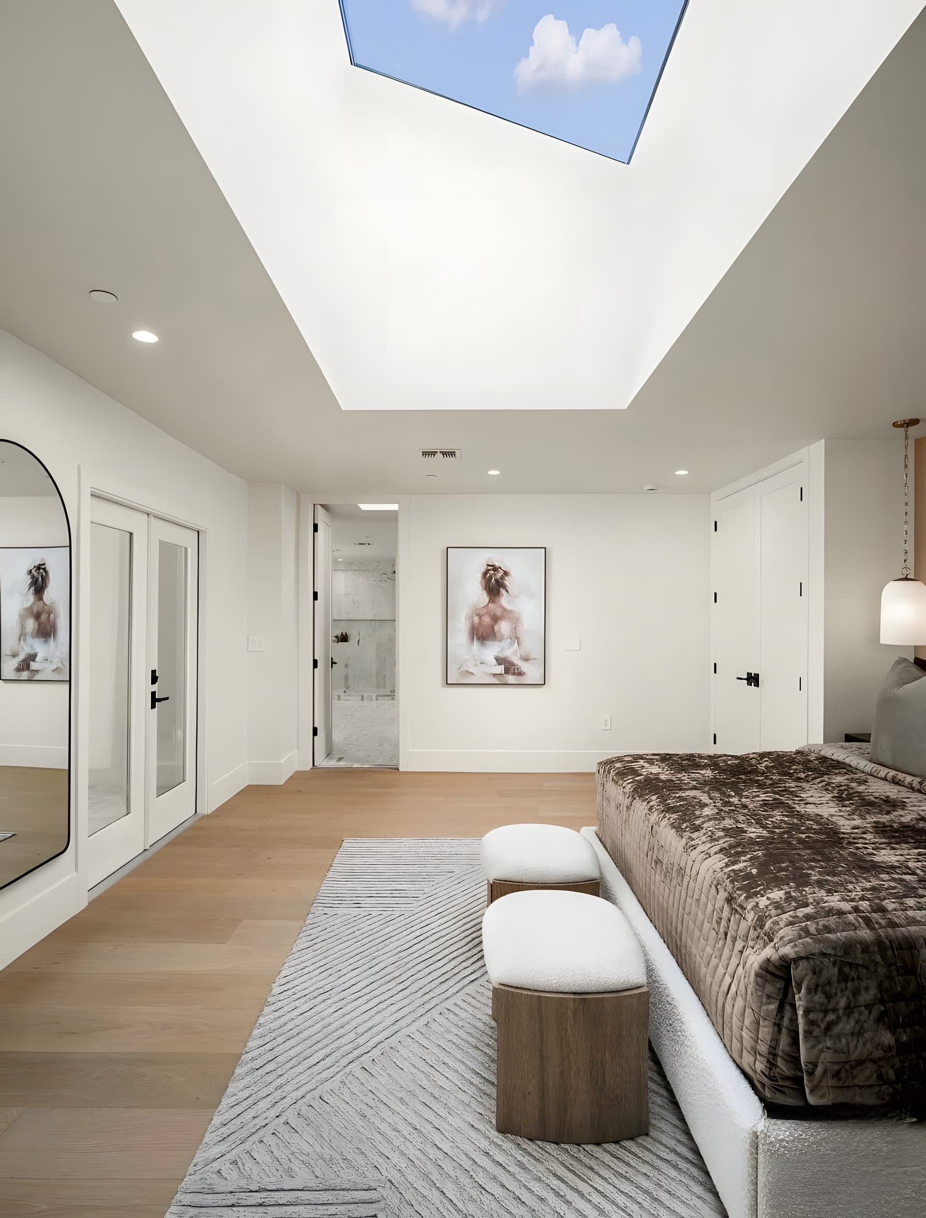 An oversized skylight transforms the primary suite — waking up to blue sky and falling asleep under the stars.