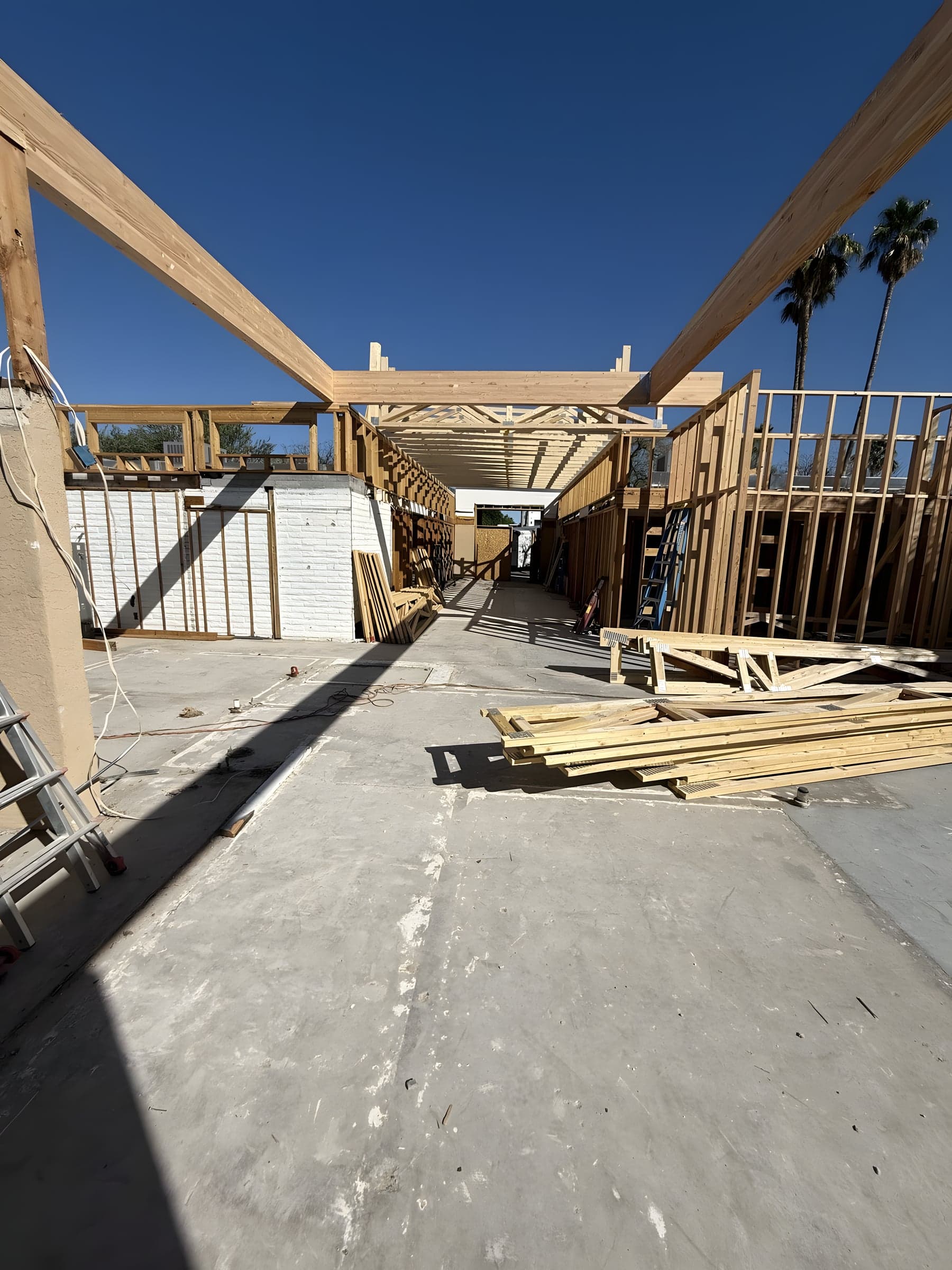 Exterior wood framing of custom home structure against blue sky